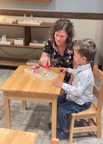 Teacher using manipulatives to teach young boy